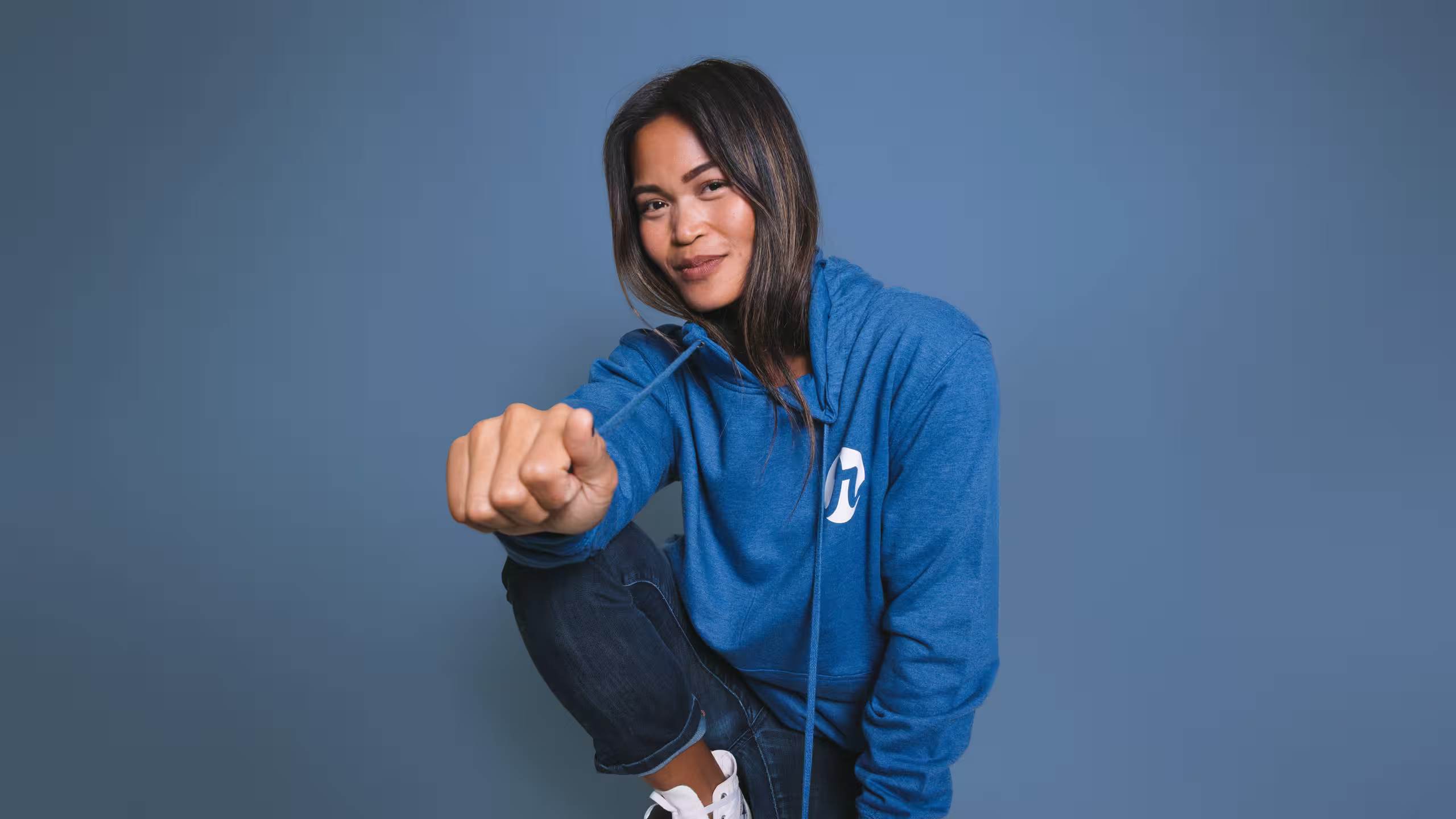 women kneeling with a blue hoodie on