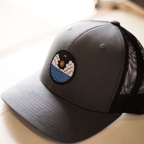 A custom hat with a patch depicting the sun over the ocean. A custom hat with a patch depicting the sun over the ocean.